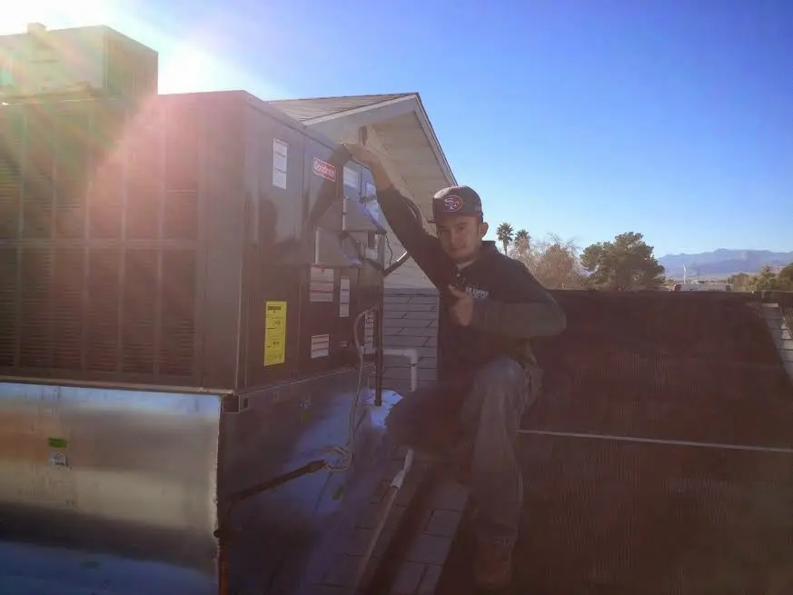HVAC technician performing Boiler Repair on a rooftop unit in Jasper